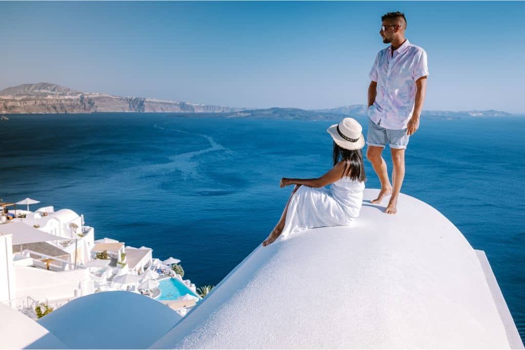 A couple enjoys the view from on high at romantic Santorini, Greece