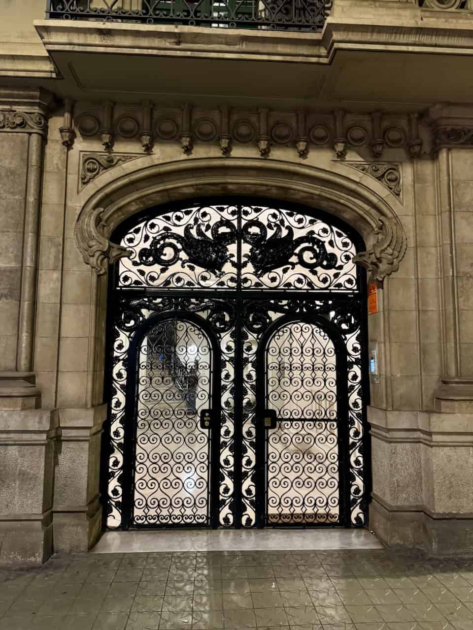 Ornate wrought iron doors on a building in Eixample, a neighborhood in Barcelona