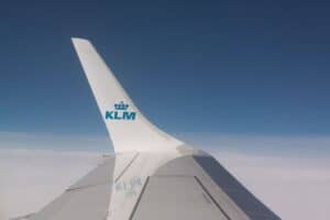 The winglet of a KLM jet stands in contrast to the blue sky.
