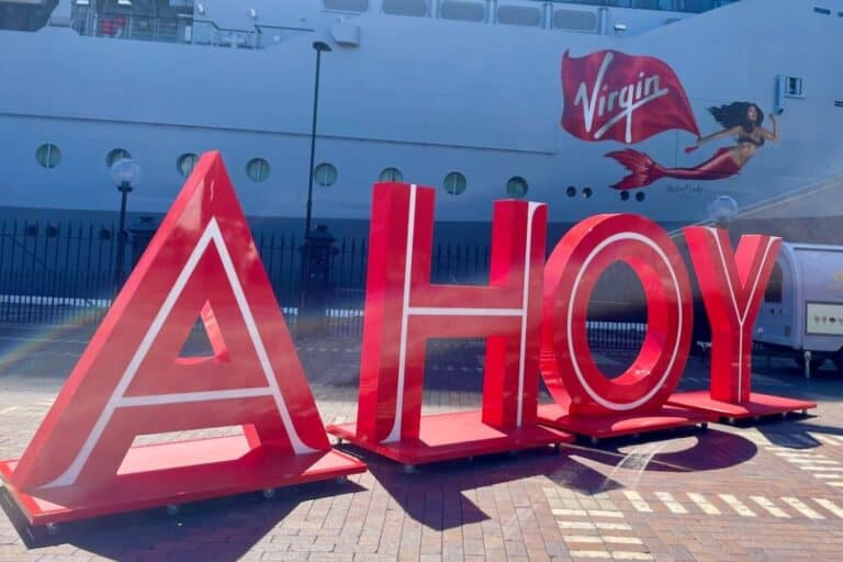 Virgin Voyages ship behind AHOY sign