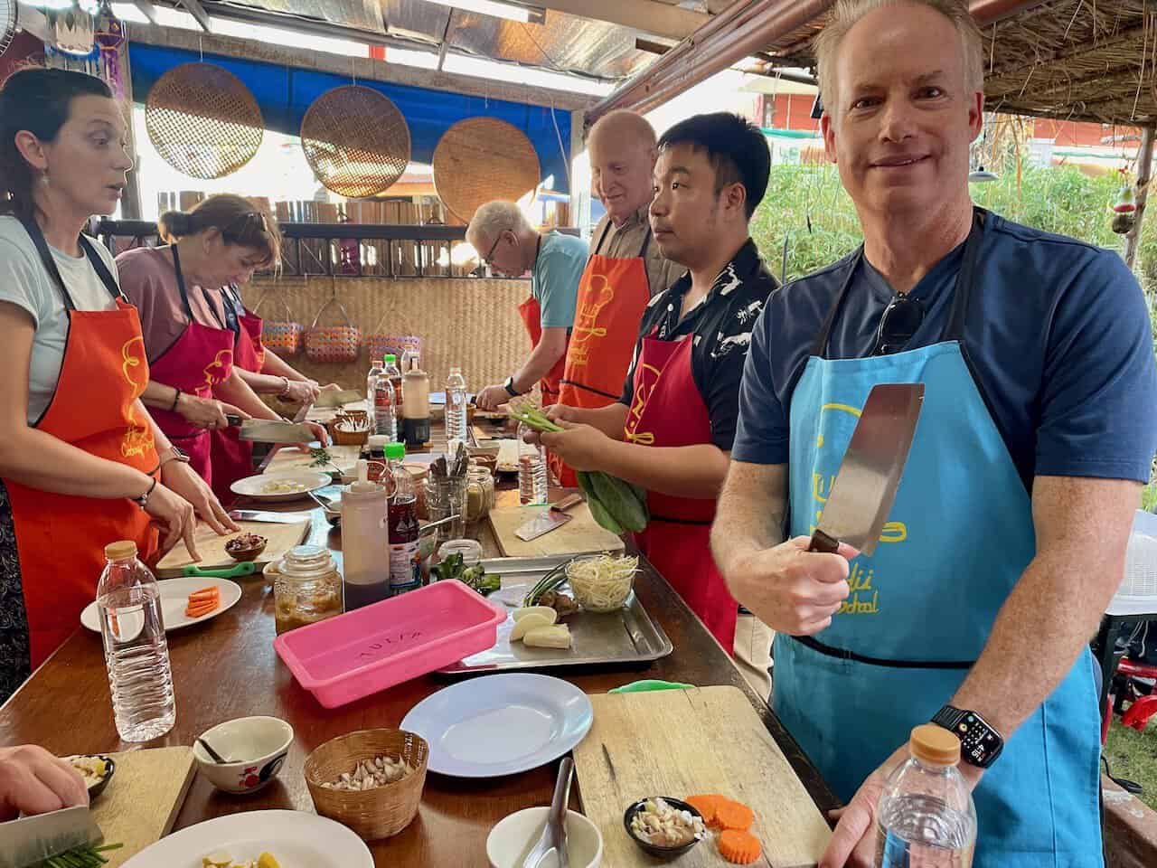Mark hold a chef's knife at a cooking class in Chiang Mai, Thailand