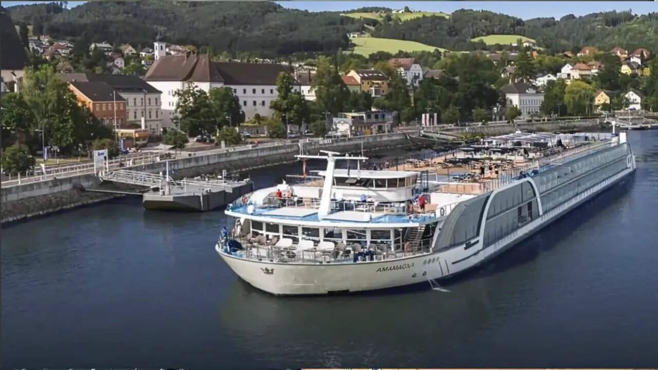 Aerial view of the AmaMagna double-wide river ship docked along a riverfront city