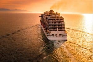 a cruise ship heads into the sunset